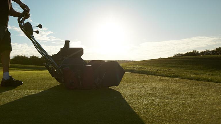 Mowing turf under summer sun